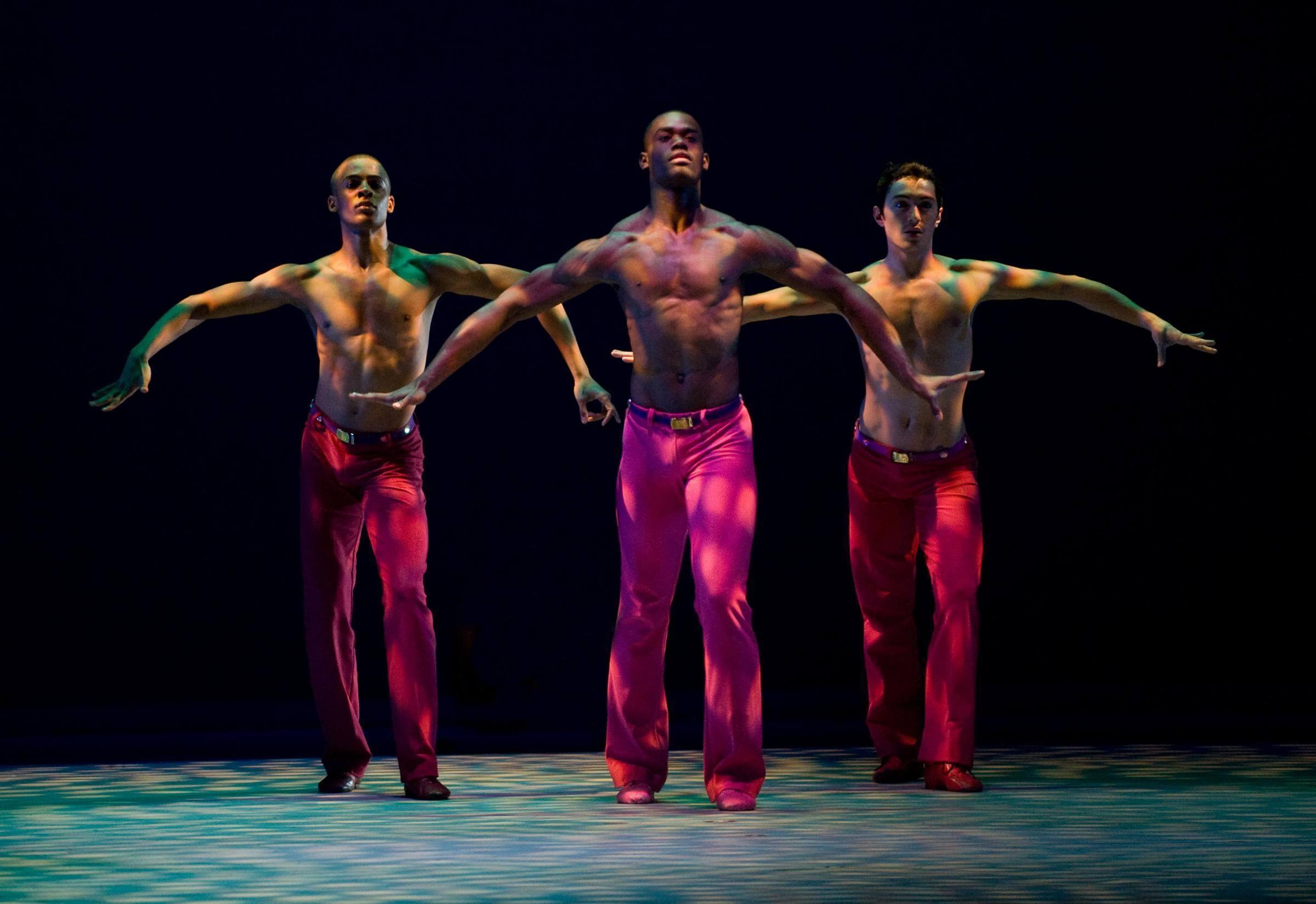 Photo of three dancers with light shining on them