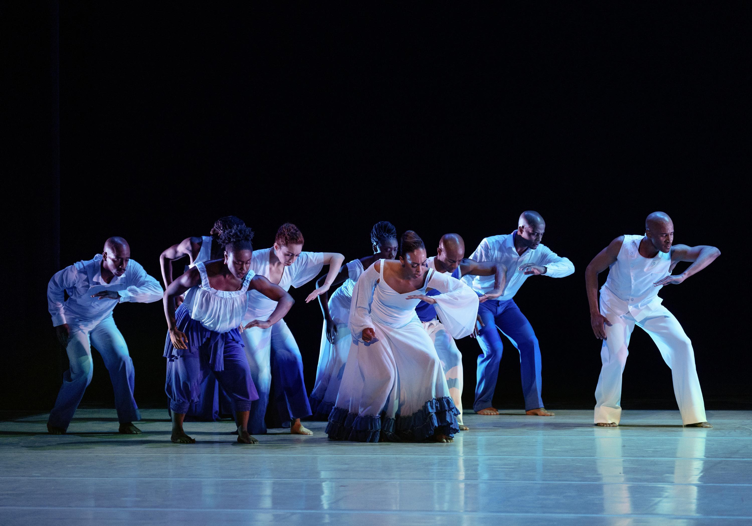 Members of the Company all leaning forward and looking down as they make the same pose