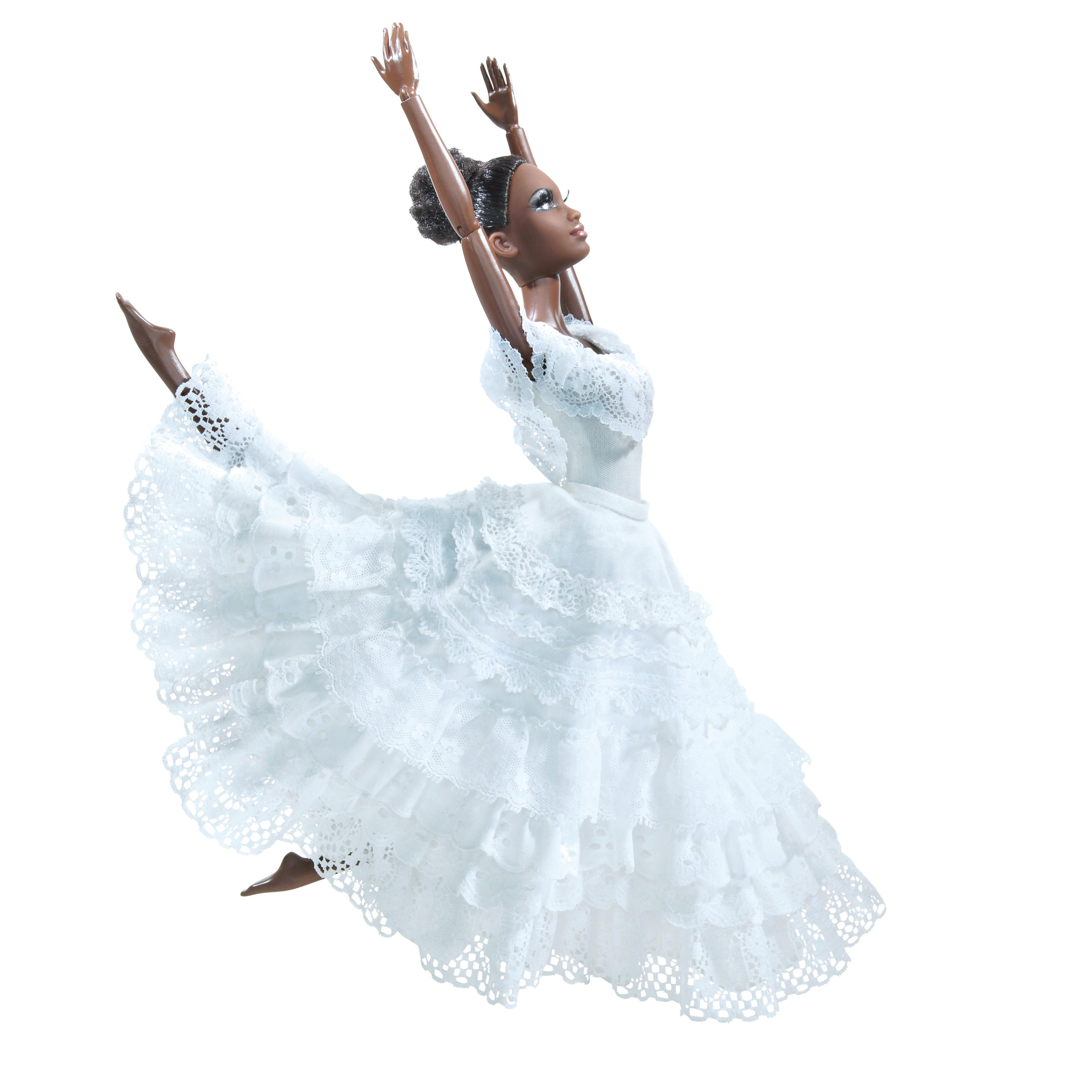 Barbie doll inspired by Alvin Ailey American Dance Theater. The doll is dressed in a white, layered lace dress, posed in a dynamic dance position with arms raised. 