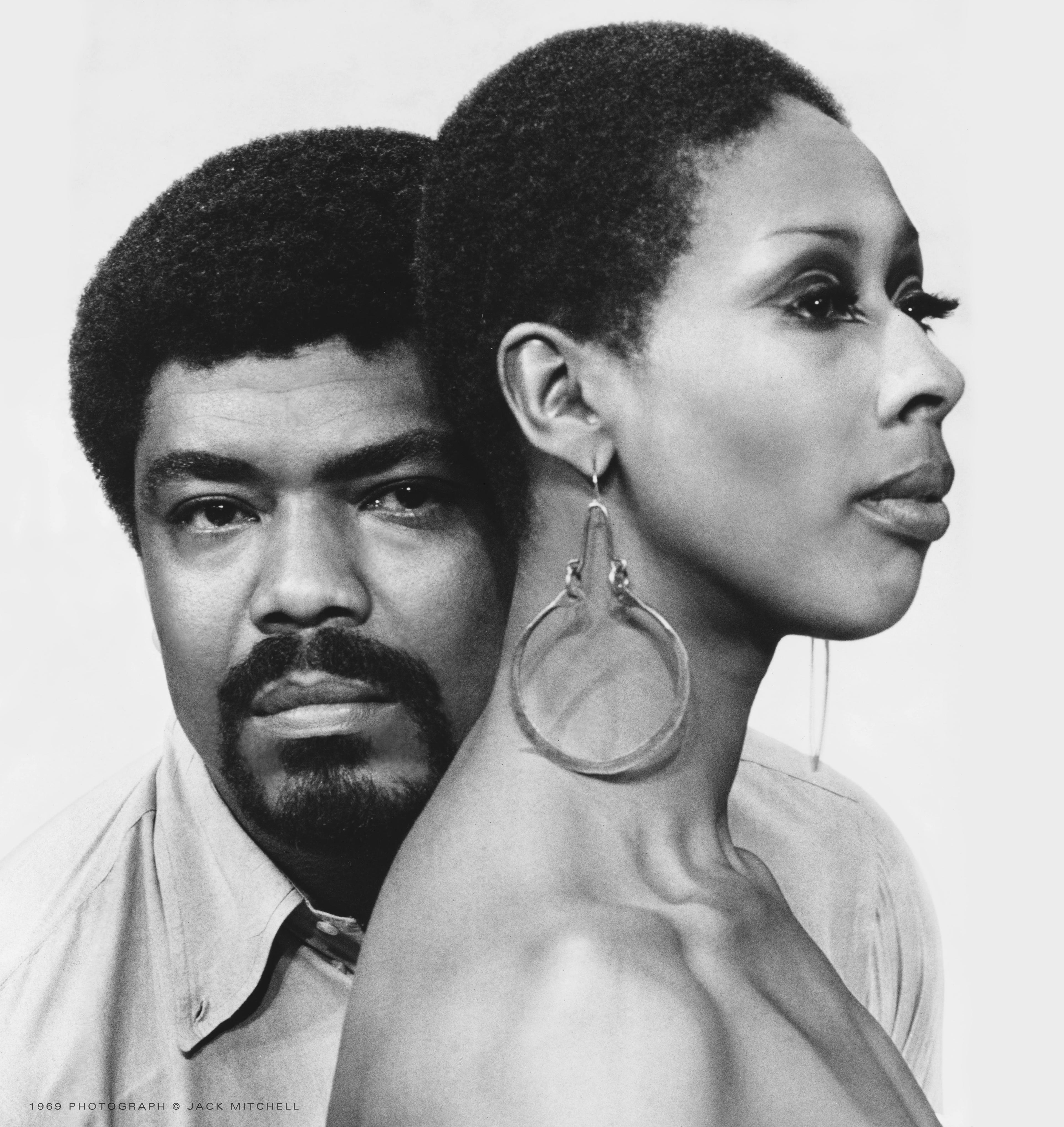 Black and white portrait of Alvin Ailey and Judith Jamison. Ailey is seen looking directly at the camera, while Jamison is in profile, gazing to the right. Both have serious expressions. Photo by Jack Mitchell, 1989.