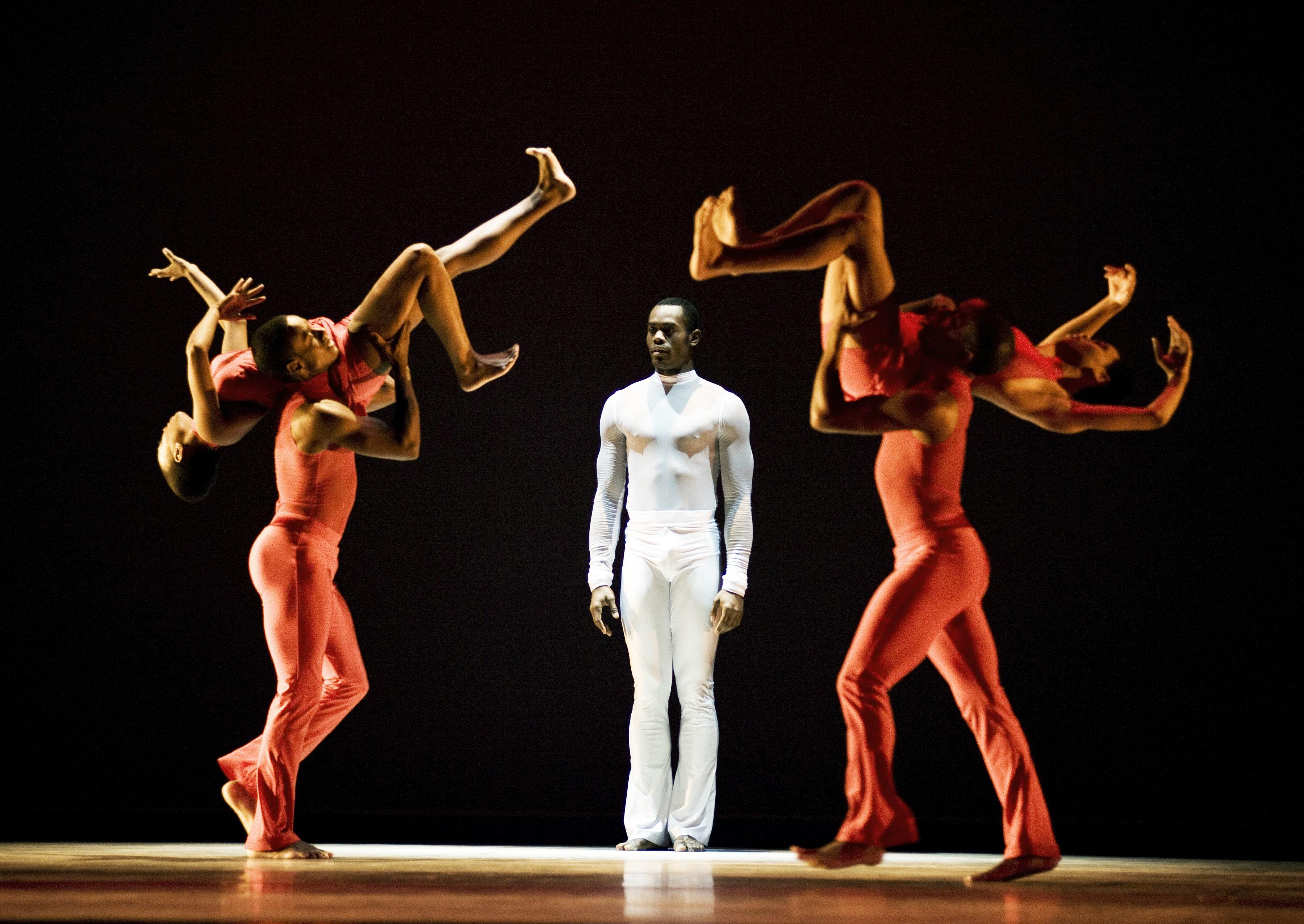 Dancing standing between two dancers with arms raised