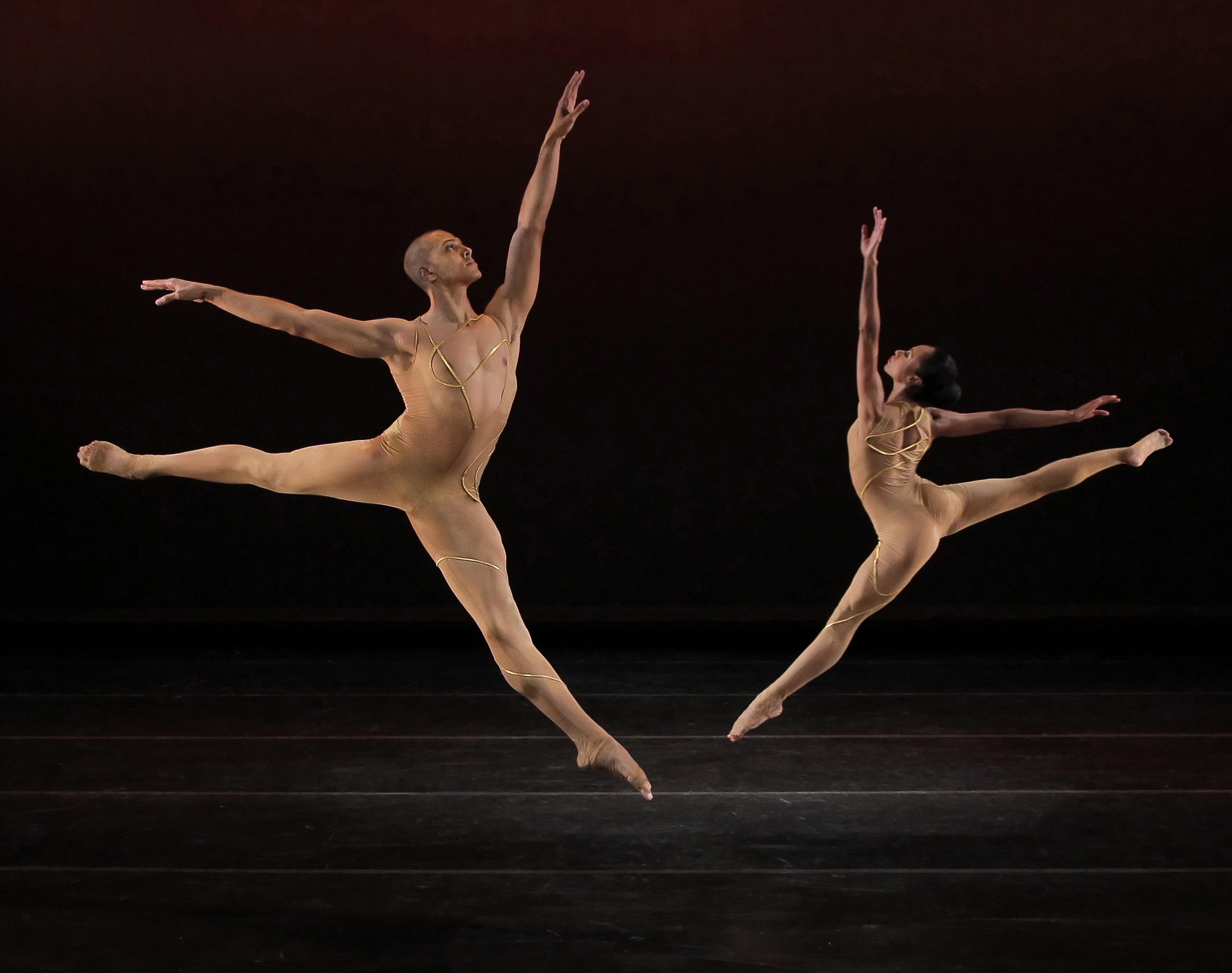 Two dancers leaping facing each other