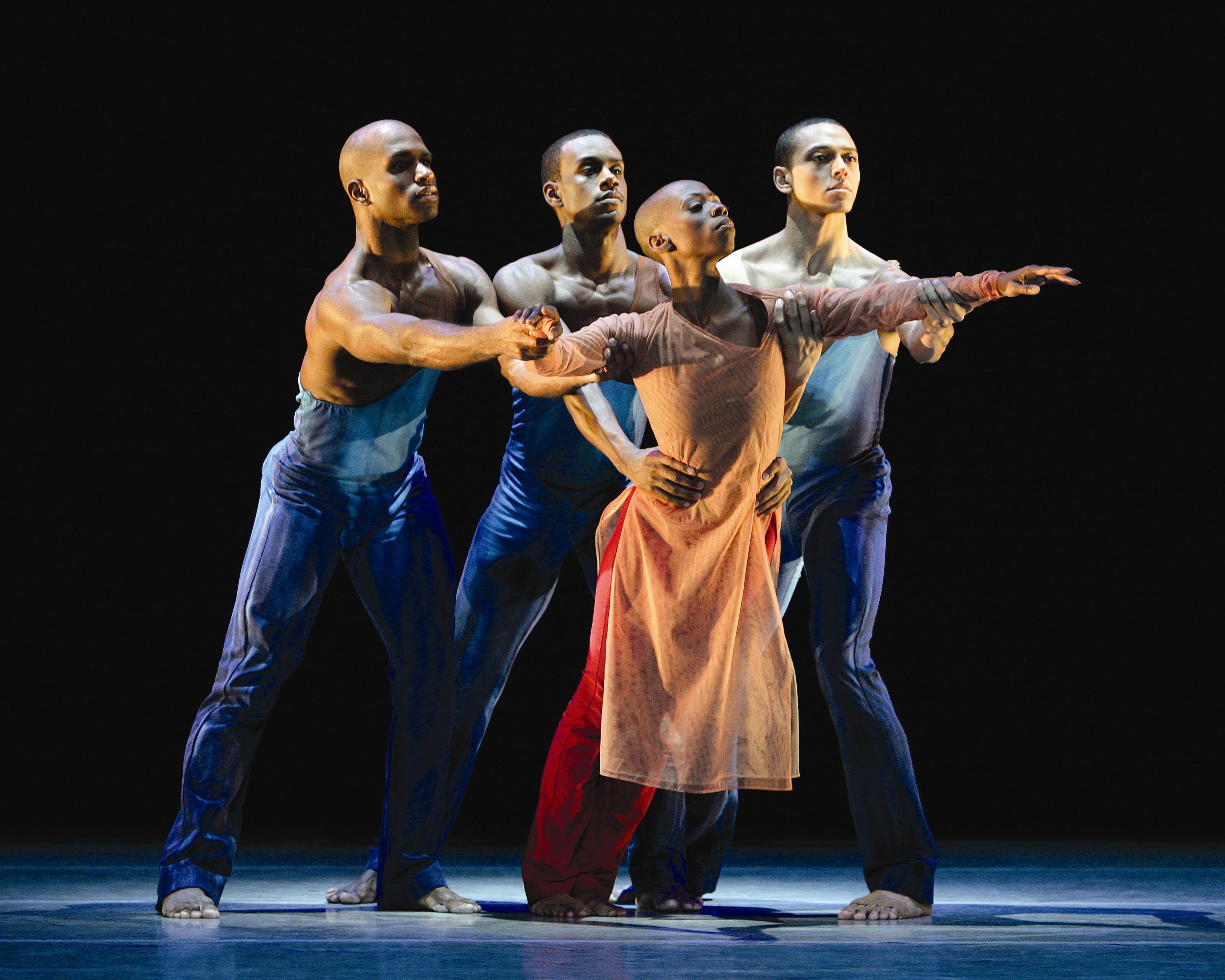 Three dancers holding a forth one that is reaching out.