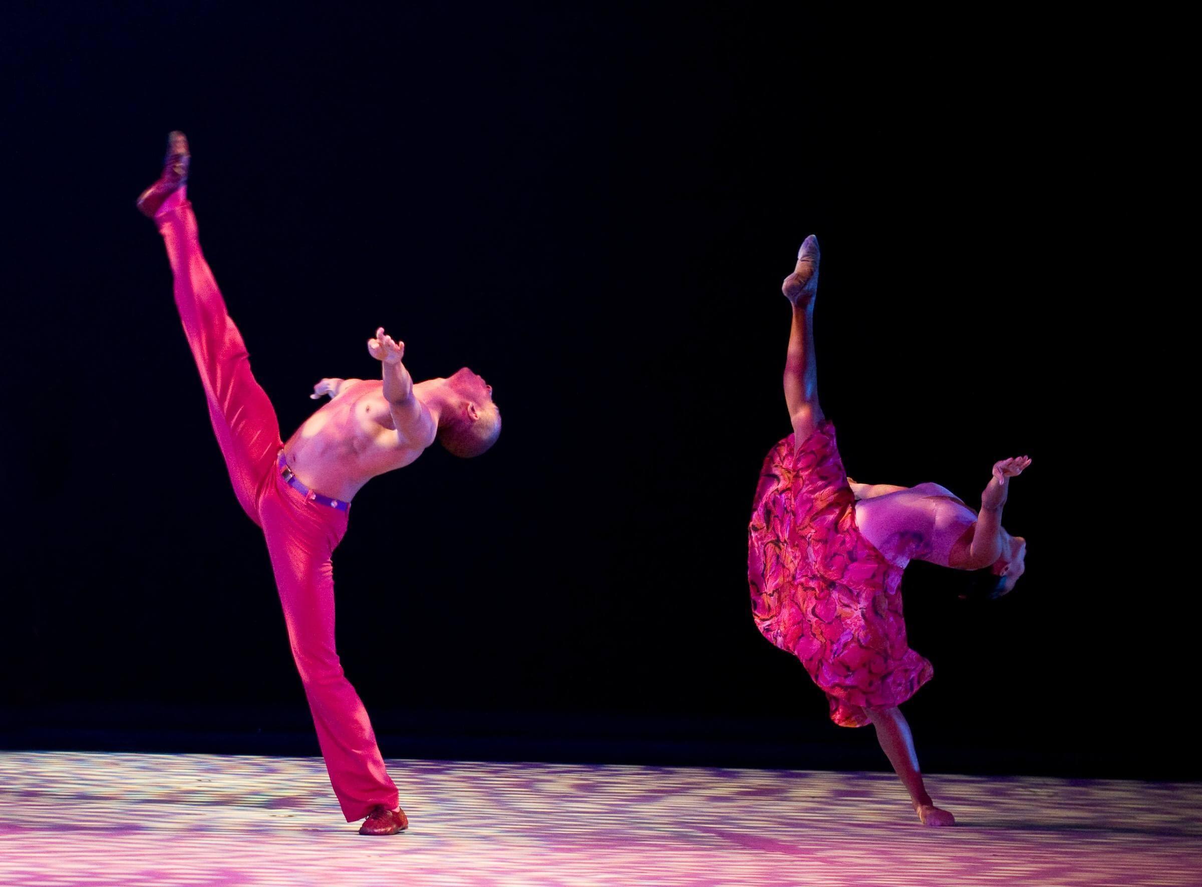 Photo of two dancers raising their legs