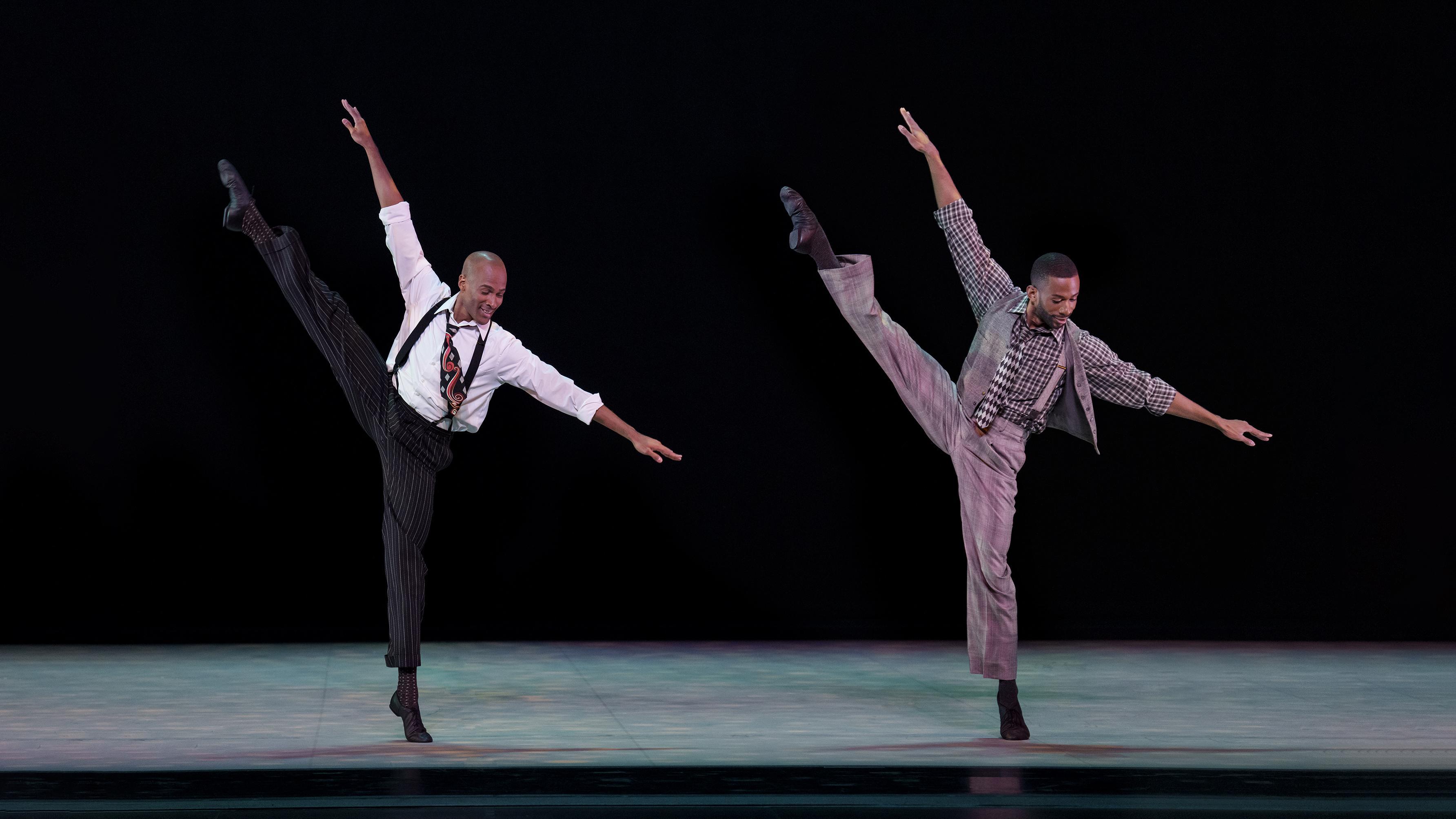 two men standing next to each with one leg in the air while tilting to the side.