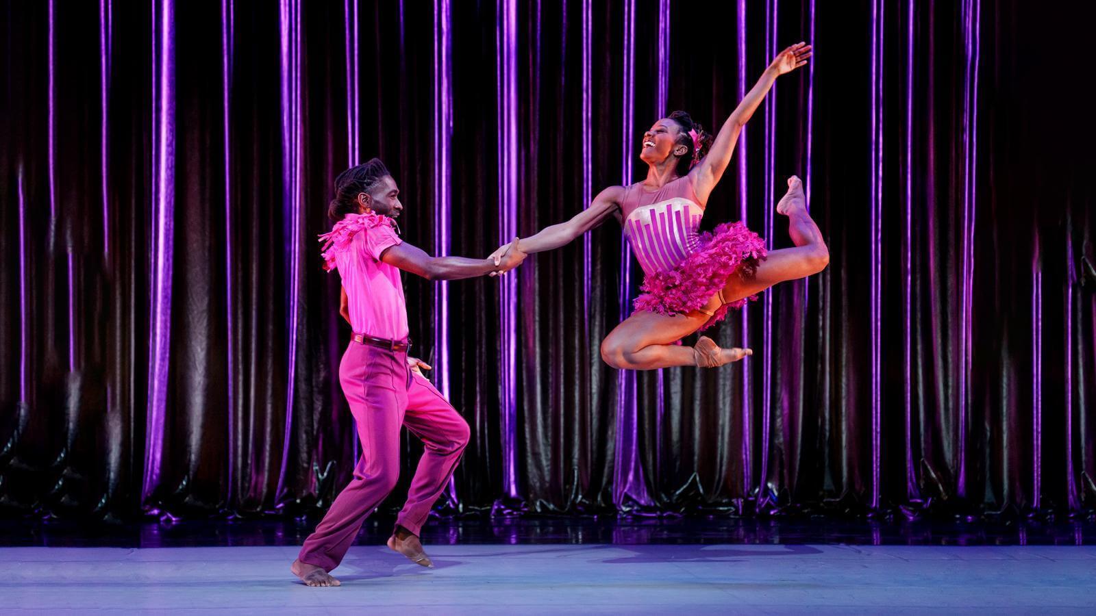 Jacquelin Harris jumping in the air and holding hands with Chalvar Monteiro