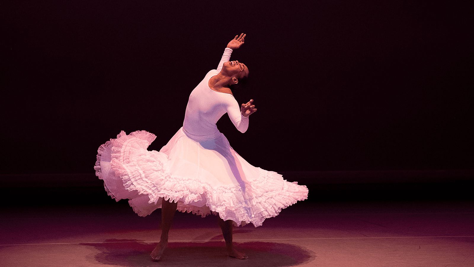 A woman in a white dress dancing on stage