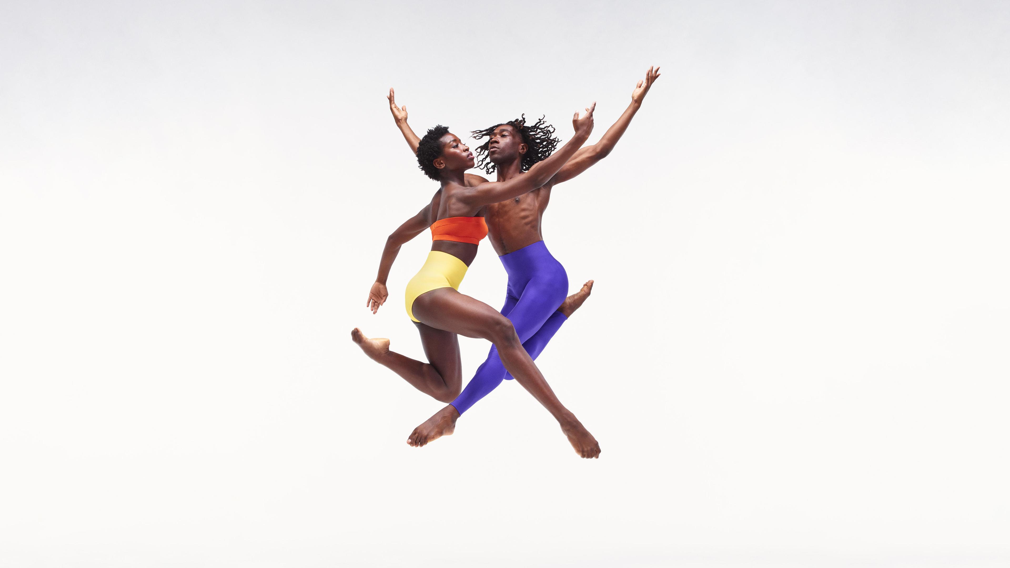 two dancers jump in the air overlaping