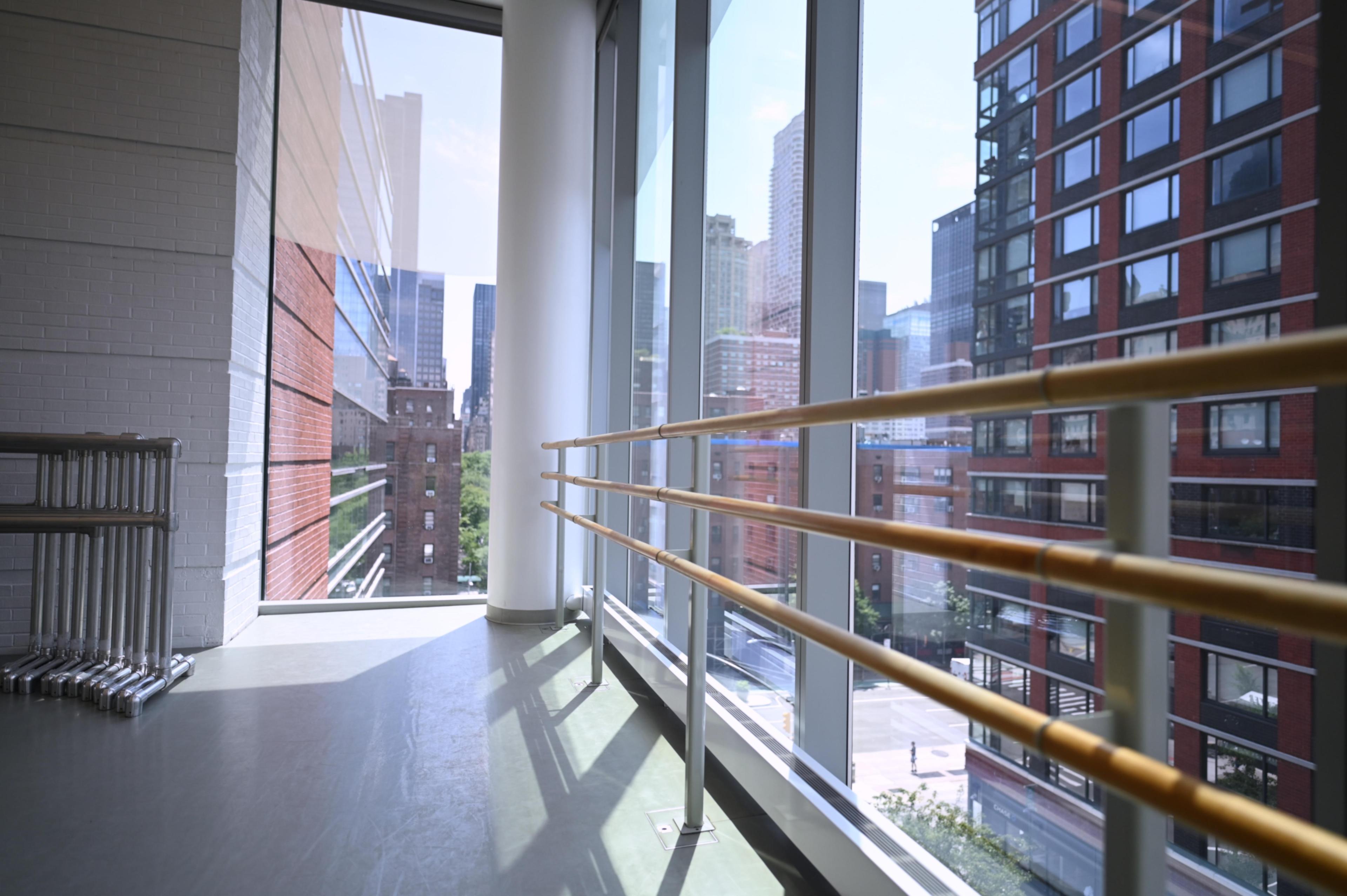 a view of a dance studio with ballet barres along the window