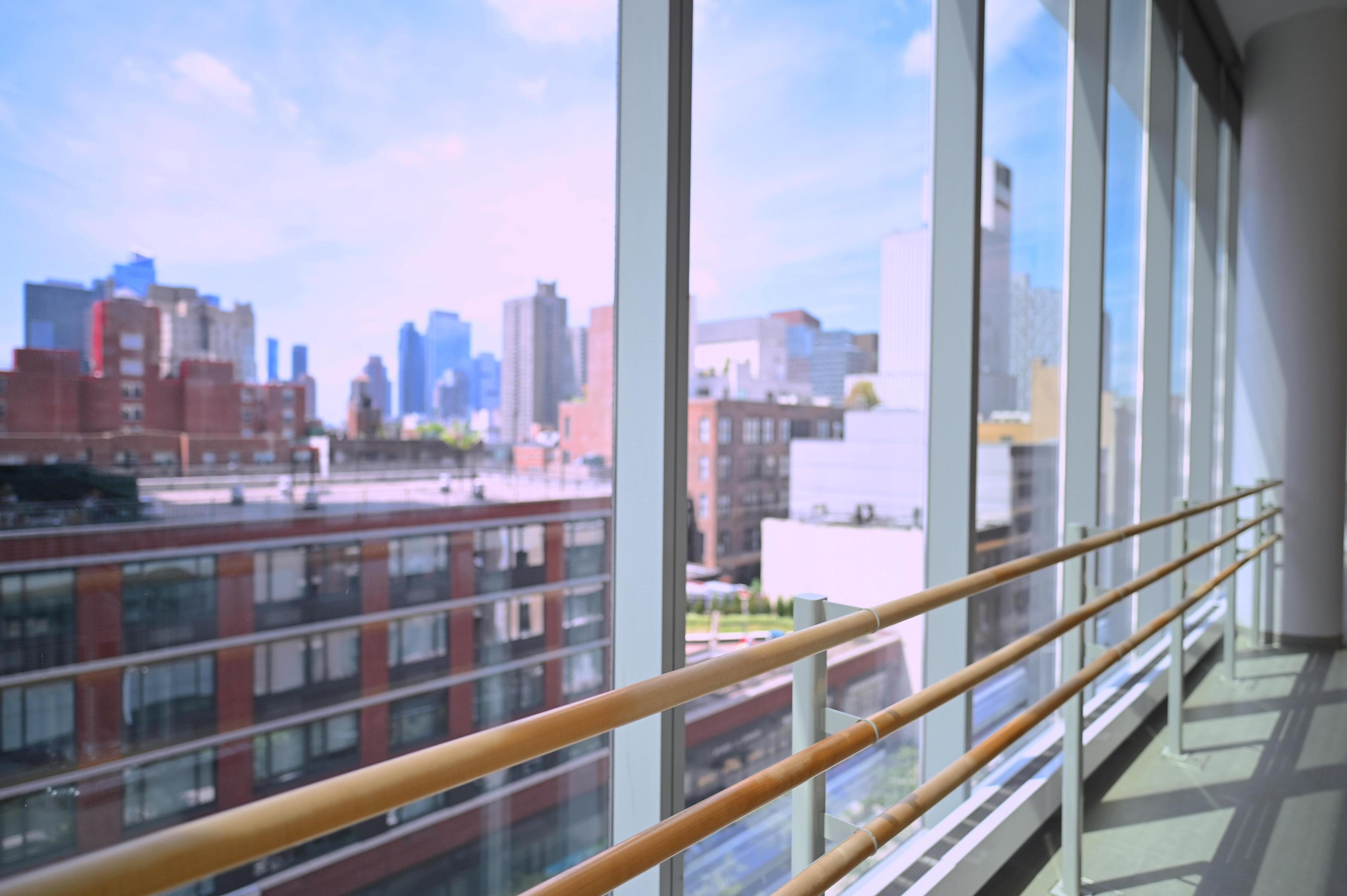 view from a dance studio with floor to ceiling windows and ballet barres